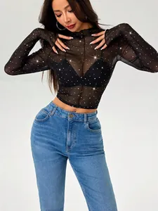 Vista detallada de un top negro de malla transparente con lentejuelas y cuello alto.