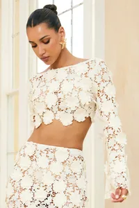 Close-up detail of the intricate white floral guipure lace on a long sleeve crop top