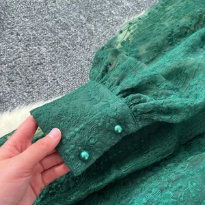 Vue détaillée de la manche lanterne brodée verte avec boutons de perles élégants