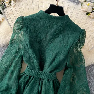 Gros plan détaillé sur la broderie verte d'une robe française vintage à manches lanternes.