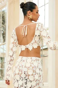 Detailed back view of white floral lace two-piece set featuring long sleeves and crop top