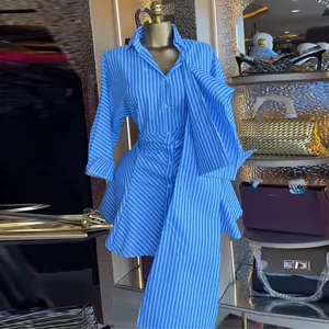 Elegant close-up of blue and white striped shirt dress with waist tie and A-line hem.