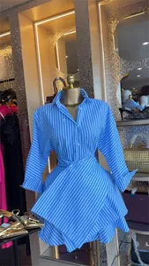 Detail view of blue and white striped shirt dress with a tiered asymmetrical skirt