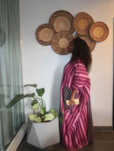 Side view of an African oversized maxi dress with pink and purple stripes