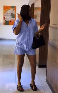 Vue d'un mannequin portant un ensemble élégant chemise et short à rayures bleues