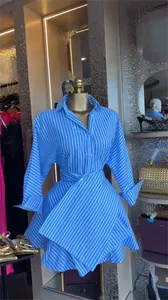 Detailed close-up view of a blue and white striped shirt dress with an asymmetrical hem