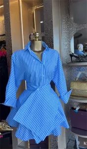 Detail of blue and white striped shirt dress featuring high waist A-line silhouette