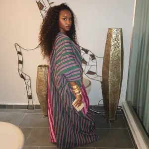Side view detail of a loose African striped maxi dress with vibrant contrast colors