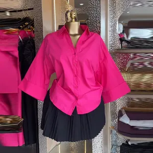 Dettaglio della camicia fucsia con maniche a pipistrello e colletto a risvolto su manichino