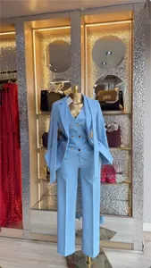 Elegant light blue women's three-piece suit set with blazer, vest, and trousers on display
