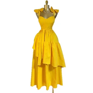 Robe d'été jaune à bretelles avec nœuds et ourlet asymétrique à volants de longueur midi.