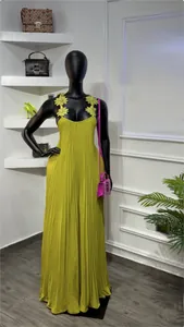 Détail montrant la texture plissée d'une robe longue vert tilleul avec bretelles fleurs 3D.