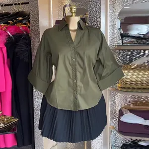 Vista dettagliata della camicia da donna verde oliva con colletto a revers e maniche a pipistrello
