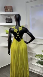 Détail de la robe maxi plissée jaune dos nu avec de superbes bretelles fleuries.