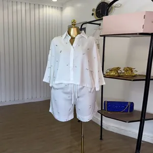 Detail van witte oversized overhemd met strassteentjes en korte broek set op de etalagepop