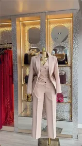Elegant nude pink three-piece women's professional suit with blazer, vest, and pants.