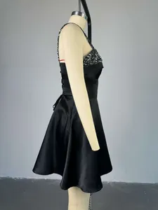 Detailed side profile of an elegant black sequined cocktail dress on a mannequin