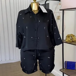 Gedetailleerd overzicht van zwarte satijnen dames set met strassteentjes en shorts