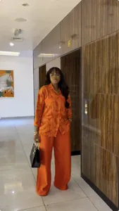 Stylish two-piece set featuring an orange printed shirt and matching wide-leg pants.