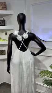 Détail d'une robe longue plissée blanche dos nu avec bretelles fleuries en 3D.