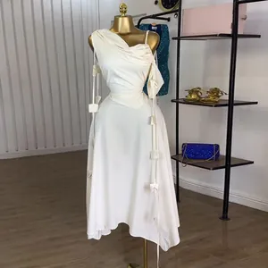 Elegant white one-shoulder midi dress featuring a high waist and decorative ribbons