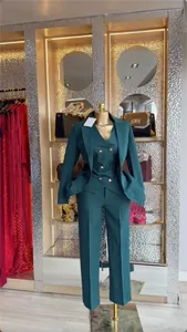 Detailed view of an elegant three-piece teal green business suit displayed on a mannequin