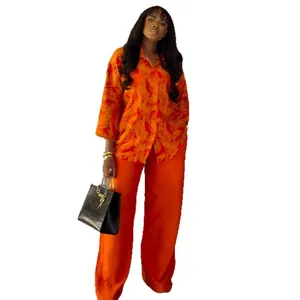 Two-piece set with vibrant orange print shirt and high-waist straight-leg pants