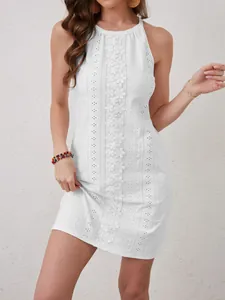 Vista detallada de elegante vestido blanco sin mangas con encaje y bordado perforado.
