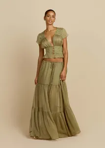 Dettaglio dell'elegante set top corto in pizzo verde oliva e gonna lunga a balze