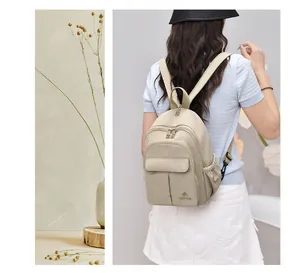 Lightweight beige nylon mini backpack for women worn in a casual outdoor setting