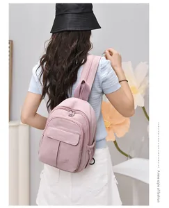 Rear view of a pink mini nylon waterproof backpack worn by a stylish model