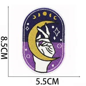 Macro detail of mystical witch embroidery patch with moon and hand, 8.5x5.5cm size