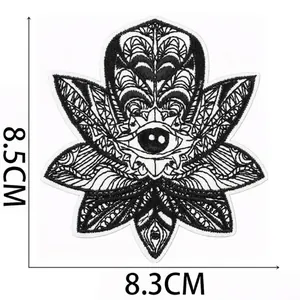 Detailed macro view of black and white evil eye embroidery patch showing size dimensions