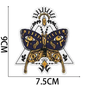 Detailed view of mystical moth embroidery patch with evil eyes and golden thread.