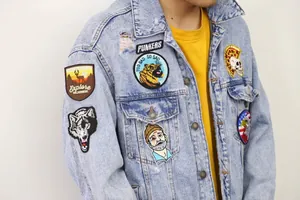 Close-up of assorted embroidered patches displayed on a denim jacket for DIY decoration