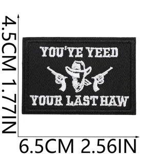 Detail of rectangular black and white cowboy theme embroidery patch with dimensions