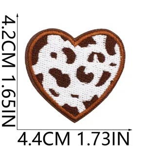 Detailed macro view of a brown cow print heart embroidered patch with dimensions.