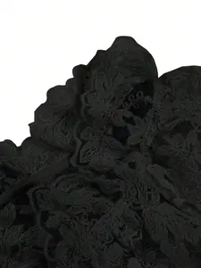 Close-up detail of intricate black floral hollow out lace fabric for women's blouse