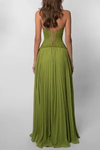 Detailed back view of a vibrant green pleated dress featuring a corset lace-up design
