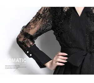 Detail of black dress featuring intricate lace embroidery and textured fabric
