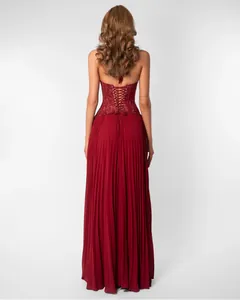 Detail view of red halter backless dress featuring elegant lace-up corset and pleated skirt