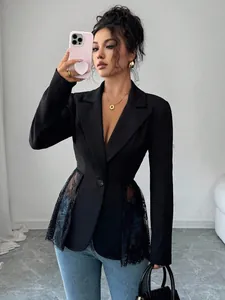 Dettaglio di blazer nero sfiancato con eleganti pannelli laterali in pizzo e vita A-line