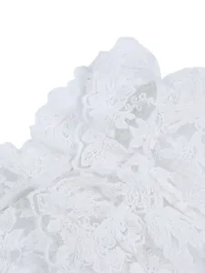 Detailed close-up of intricate white floral lace and embroidery on a women's shirt