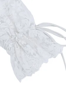 Close-up of white hollow-out lace embroidery on blouse cuff