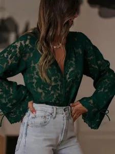 Close-up detail of dark green floral lace blouse with elegant hollow-out embroidery texture