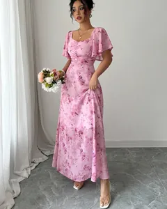 Detailed view of pink floral maxi dress with elegant ruffle sleeves and slim waistline.