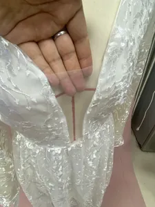 Detailansicht des transparenten Netzausschnitts und der floralen Spitze am Hochzeitskleid