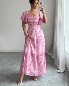 Full view of elegant pink floral maxi dress with ruched bodice and flutter sleeves.