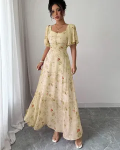 Detail view of elegant yellow floral maxi dress with flutter sleeves and slim fit