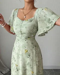 Close-up of green floral print dress with elegant flutter sleeves and ruffles